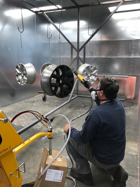 Wheels being powder-coated in the spray booth at Superior Powder Coating, Clarksville TN
